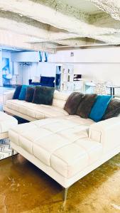 una sala de estar con un gran sofá blanco en Huge Downtown LA Loft with Rooftop Pool & Jacuzzi, en Los Ángeles