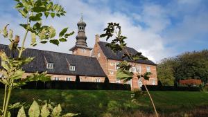 ein großes Backsteingebäude mit einem Uhrturm oben in der Unterkunft Sleeptide in Husum