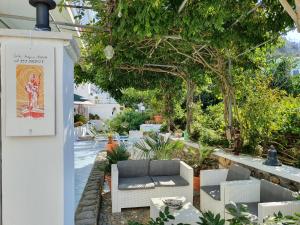 un giardino con divano, sedie e alberi di Casa Acqua Marina Ponza a Ponza