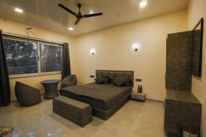 a bedroom with a bed and a ceiling fan at AGP Nature Villa in Udaipur