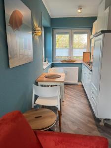 eine kleine Küche mit einem roten Sofa und einem Tisch in der Unterkunft Rosenhus 5 in Horumersiel