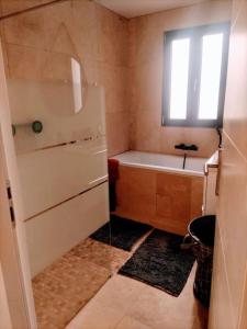 uma pequena casa de banho com uma banheira e um lavatório em Maison de ville avec jardin, proche vignoble em Courthézon