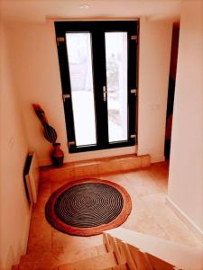una stanza con un grande tappeto rotondo sul pavimento accanto a una finestra di Maison de ville avec jardin, proche vignoble a Courthézon
