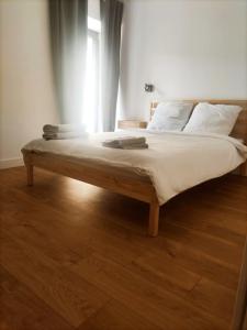 uma cama grande num quarto com piso em madeira em Maison de ville avec jardin, proche vignoble em Courthézon