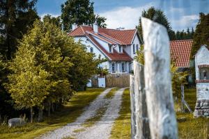uma casa branca com uma cerca numa estrada de terra em Farm & Country House Gizewo 32 em Sorkwity