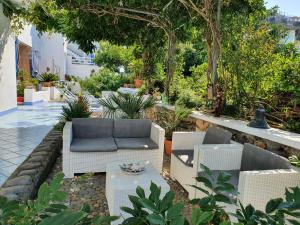 eine Terrasse mit einem Sofa, Stühlen und einem Tisch in der Unterkunft Casa Acqua Marina Ponza in Ponza