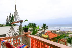 een balkon met een hangmat en uitzicht op het strand bij Alma Olon in Olón