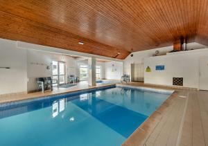 a large swimming pool with a wooden ceiling at Flat 9 Clifton Court in Croyde