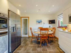 una cucina con tavolo, sedie e frigorifero di 2 bed property in Nairn The Highlands 89176 a Nairn