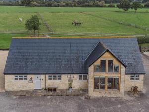 a house with a black roof and a horse in a field at 3 bed in Shaftesbury 85551 in Stour Provost