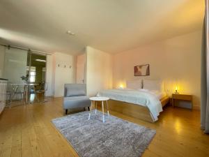 a bedroom with a bed and a chair and a table at Studio im Zentrum von Lochau, #1 in Lochau