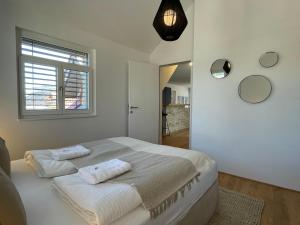 ein Schlafzimmer mit einem Bett mit zwei Handtüchern darauf in der Unterkunft VINCENT Loft in der Innenstadt in Bregenz