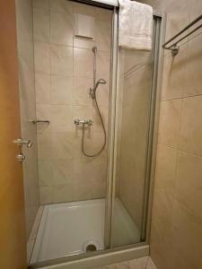 La salle de bains est pourvue d'une douche avec une porte en verre. dans l'établissement International House Sölden Standard Apartment ZW 10, à Sölden