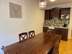 cocina con mesa de madera y algunas sillas en International House Sölden Apartment mit Balkon ZW 12, en Sölden