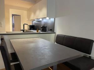 una cucina con tavolo, sedie e bancone di International House Sölden Apartment mit 3 Schlafzimmern ZW AP 6 a Sölden