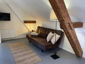 un salon avec un canapé brun et une lampe dans l'établissement Studio im Zentrum von Lochau, #3, à Lochau