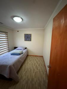 a bedroom with a bed and a wooden door at Casa En Papudo Lomas del Mar in Papudo