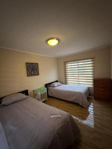 a bedroom with two beds and a window at Casa En Papudo Lomas del Mar in Papudo