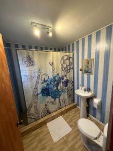 a bathroom with a toilet and a shower curtain at Casa En Papudo Lomas del Mar in Papudo