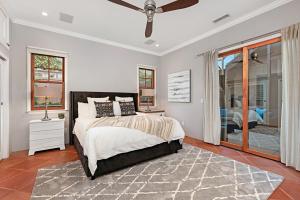 1 dormitorio con 1 cama y ventilador de techo en Rooftop Oceanview Patio - 5BR Remodeled Home, en Carlsbad