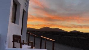 un edificio con un balcón con puesta de sol en el fondo en Casa Saboa, en San Bartolomé