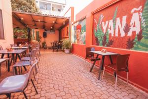 un patio vide avec des tables et des chaises dans un restaurant dans l'établissement Poente Hostel, à Belo Horizonte