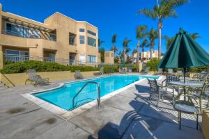 a swimming pool with a table and an umbrella at Lagoon Views - Pool - Hot Tub - Gated Community in Carlsbad
