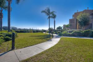 a walkway through a park with palm trees at Lagoon Views - Pool - Hot Tub - Gated Community in Carlsbad