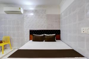 - une petite chambre avec un lit et une chaise jaune dans l'établissement OYO Hotel Golden Pride, à Shamshabad