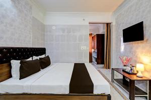 a bedroom with a large bed and a table at OYO Hotel Golden Pride in Shamshabad
