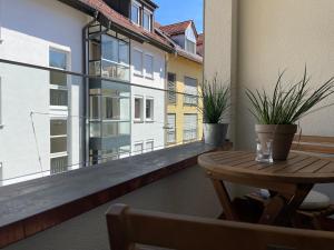 VINCENT Apartment in Bregenz mit Parkplatz في بريغنز: شرفة مع طاولة ونصبات الفخار عليها