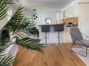 ein Wohnzimmer mit 2 Stühlen und eine Küche in der Unterkunft VINCENT Apartment in Bregenz mit Parkplatz in Bregenz