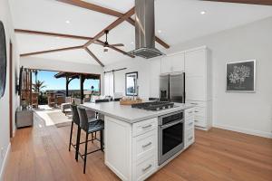 a kitchen with white cabinets and a table with chairs at Oceanview Rooftop Patio - Walk To The Beach & Park in Carlsbad