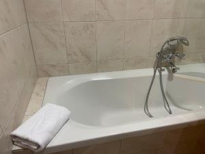 eine weiße Badewanne im Bad mit einem Handtuch in der Unterkunft International House Sölden Deluxe Apartment ZW 13 in Sölden