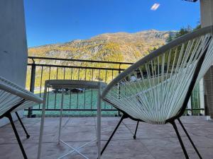 einen Stuhl und einen Tisch auf einem Balkon mit Aussicht in der Unterkunft International House Sölden Deluxe Apartment ZW 13 in Sölden