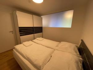 een slaapkamer met 2 bedden en witte lakens bij International House Sölden Apartment mit 1 Schlafzimmern ZW AP 5 in Sölden
