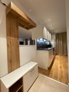 eine Küche mit weißen Schränken und Holzböden in der Unterkunft International House Sölden Apartment mit 1 Schlafzimmern ZW AP 5 in Sölden