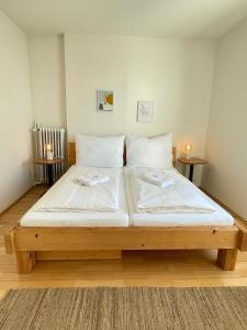 a large bed in a room with two tables at Studio im Zentrum von Lochau, #5 in Lochau