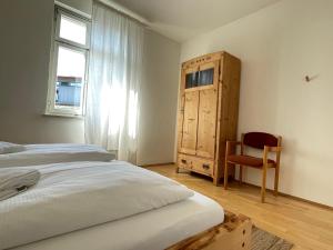 a bedroom with two beds and a wooden cabinet at Studio im Zentrum von Lochau, #5 in Lochau