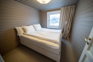 a small bed in a room with a window at Brensholmen Beach House in Tromsø