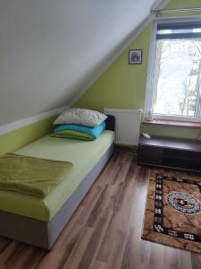 a small bedroom with a bed and a window at Domek Żegary in Sejny