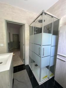 a glass cabinet in a bathroom with a sink at Casa em Charneca de Caparica in Charneca