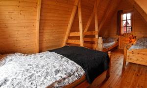 a bedroom with two beds in a log cabin at Rodzinne Wczasy pod Gruszą in Gąski