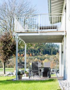 um pátio com um deque e uma mesa na relva em Ferienwohnung im Allgäu - Biber 2 em Leutkirch im Allgäu