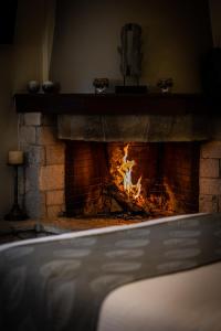 a brick fireplace with a fire in it at MARON ΙΙ με τζάκι in Kalavrita