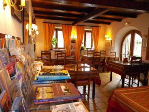 een restaurant met tafels, stoelen en boeken bij A l'arc en ciel in Blaesheim