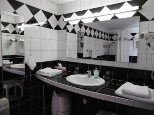 uma casa de banho com 2 lavatórios e um espelho grande em A l'arc en ciel em Blaesheim