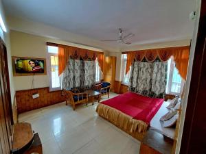 a bedroom with a bed and a table and chairs at Hotel Snow Mountain Mall Road in Manāli