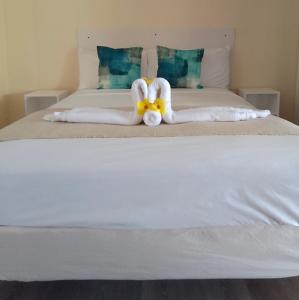 uma cama com dois cisnes feitos de toalhas em Point Bay Resort em Calliaqua
