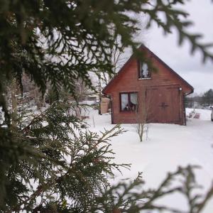 un granero rojo en la nieve con una ventana en Domek Żegary, en Sejny